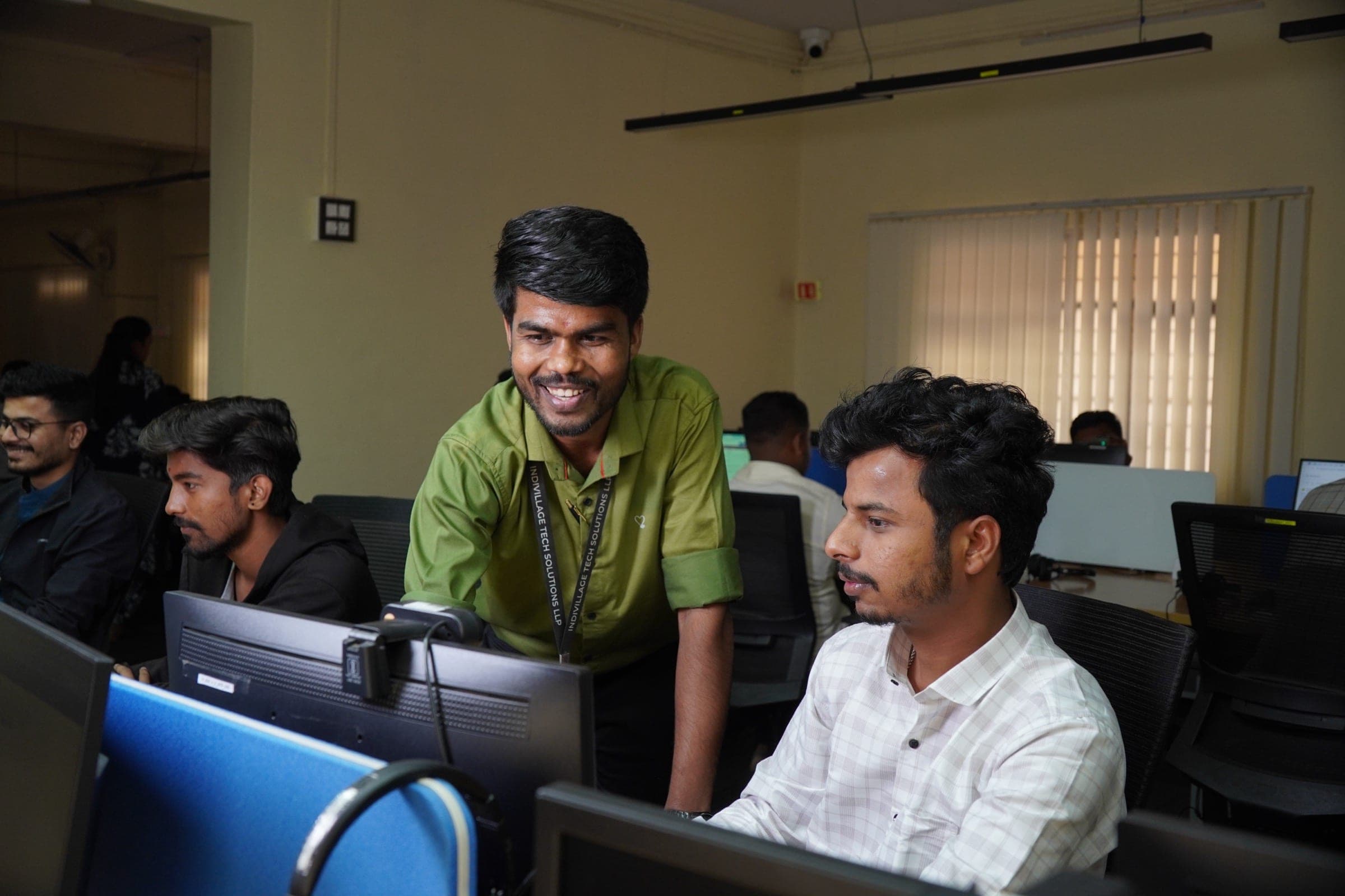 IndiVillage robotics specialists reviewing egocentric footage together at the delivery floor in India